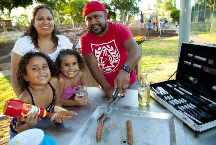 Family of four grilling in a park