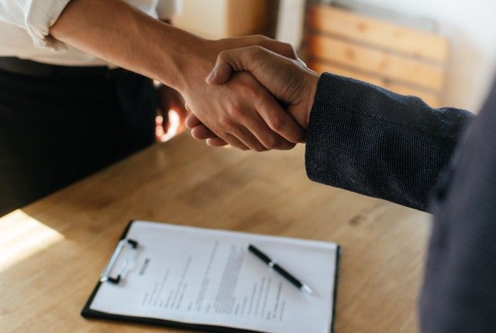 Two People Shaking hands over an Area Migration Agreement 