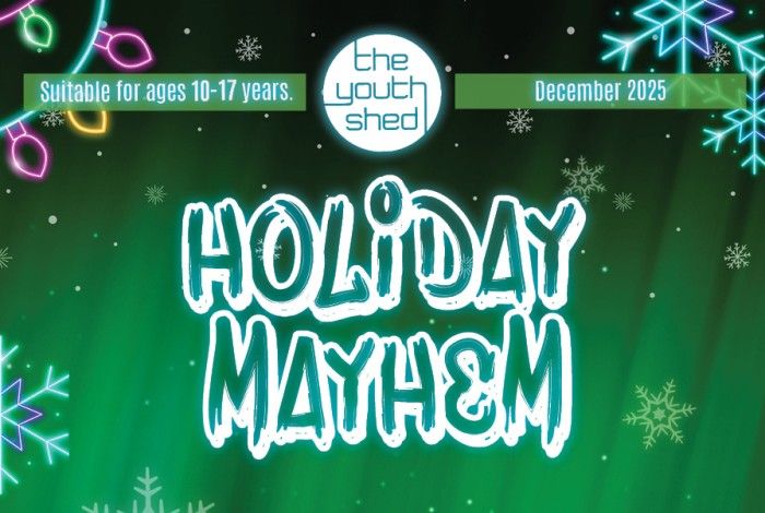 A festive digital poster for The Youth Shed’s “Holiday Mayhem.” The background features glowing green lights, neon Christmas bulbs, and snowflakes. At the top, a banner reads “Suitable for ages 10–17 years” and “December 2025.” The Youth Shed logo sits in the centre. Large bold text says “Holiday Mayhem” in white graffiti-style lettering.