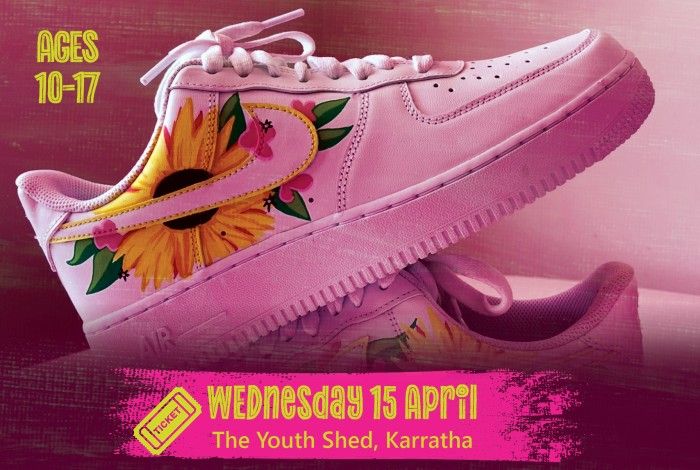 Close-up of a white sneaker customised with colourful floral artwork including large yellow flowers and pink blossoms. A pink banner reads “Wednesday 15 April – The Youth Shed, Karratha,” and text on the left says “Ages 10–17.”