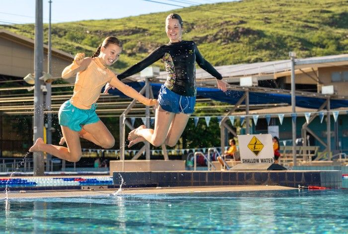 Two children jumping into the KLP swimming pool